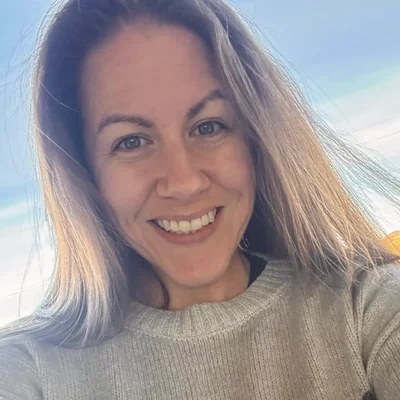 Valerie smiling in a sunlit outdoor selfie